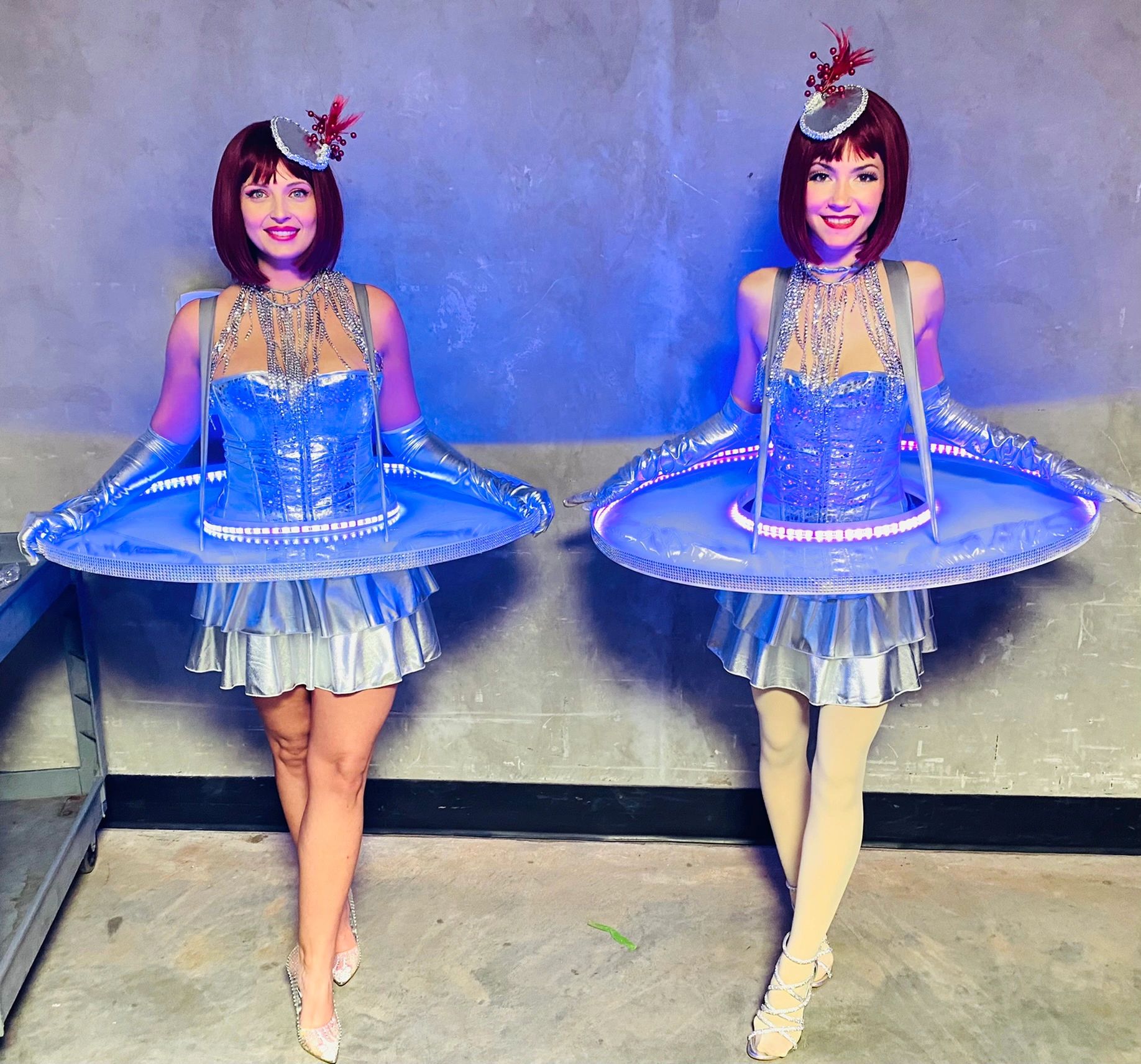Two performers in matching futuristic blue sequined costumes